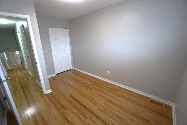 unfurnished bedroom with a closet and light hardwood / wood-style flooring