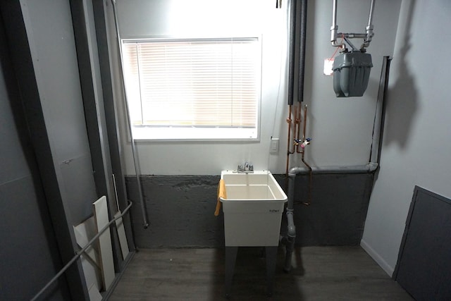 clothes washing area featuring sink and dark hardwood / wood-style floors