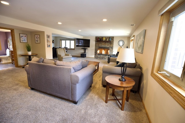 living room featuring light colored carpet and a fireplace