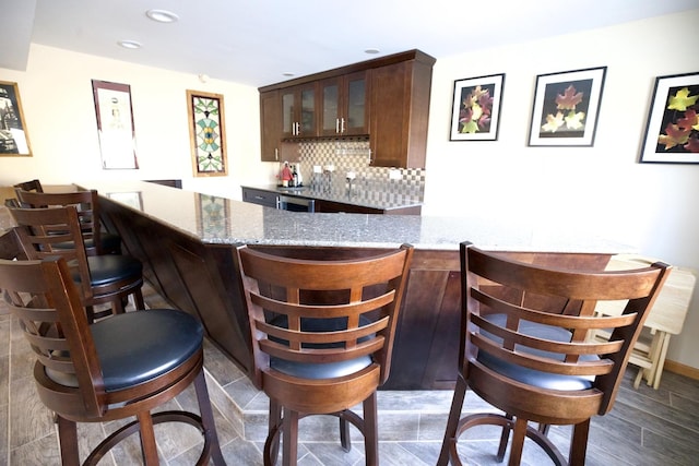 bar featuring light stone countertops and backsplash