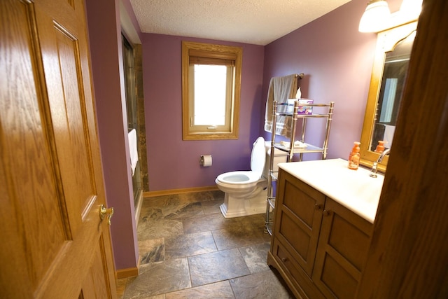 bathroom with vanity, a textured ceiling, and toilet