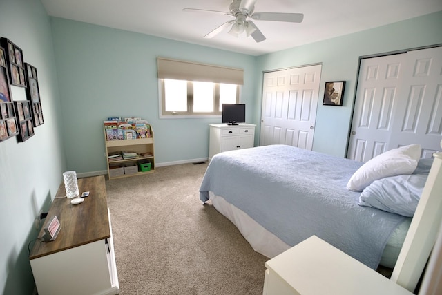 bedroom featuring multiple closets, ceiling fan, and carpet