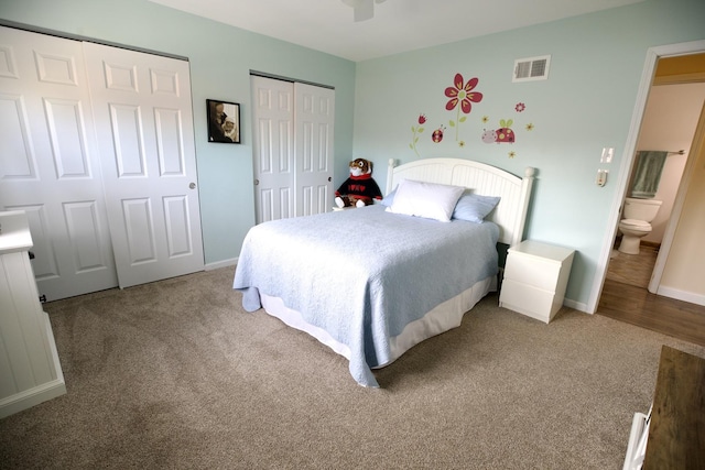 bedroom featuring multiple closets, carpet floors, and ensuite bath