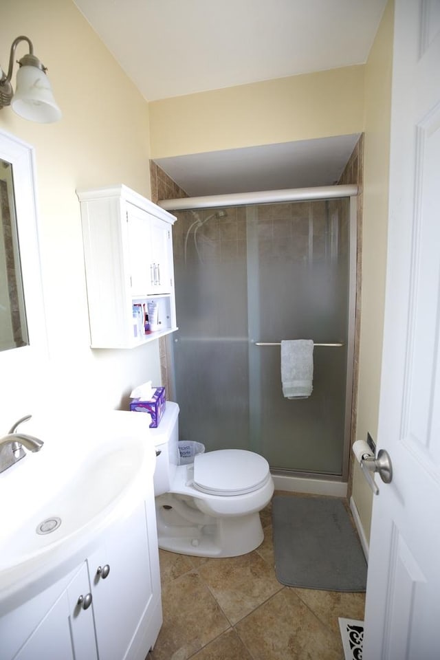 bathroom featuring a shower with door, vanity, tile patterned floors, and toilet