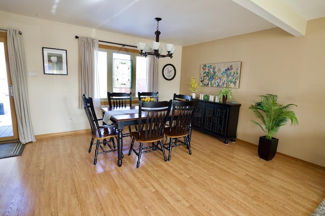 dining area featuring beamed ceiling, a notable chandelier, and light hardwood / wood-style floors