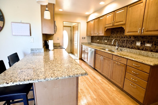 kitchen featuring stainless steel appliances, sink, pendant lighting, and a kitchen bar