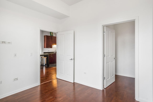 unfurnished bedroom with dark hardwood / wood-style flooring