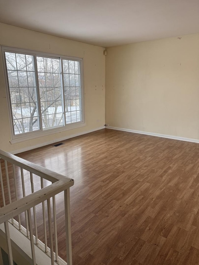 spare room featuring hardwood / wood-style flooring and a wealth of natural light