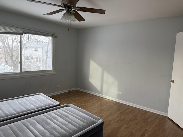 unfurnished bedroom with dark hardwood / wood-style floors and ceiling fan