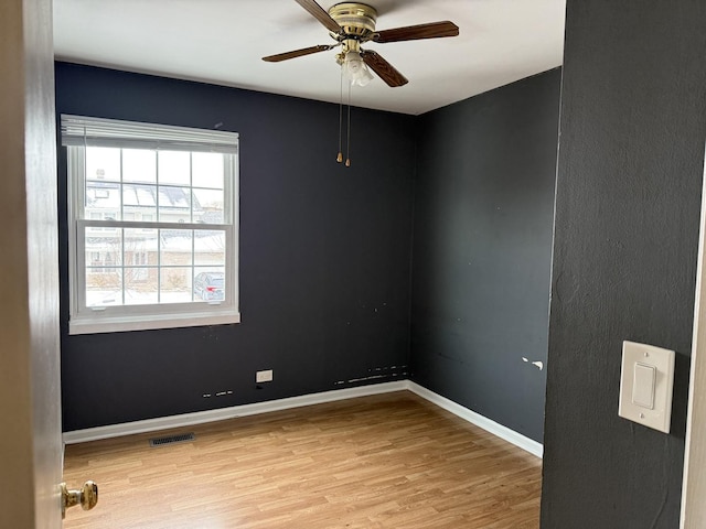 spare room with ceiling fan and light wood-type flooring