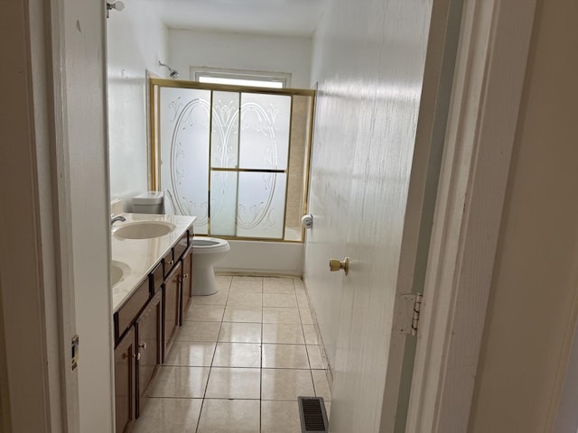 full bathroom featuring vanity, tile patterned floors, shower / bath combination with glass door, and toilet