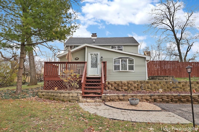 rear view of property featuring a deck and a lawn