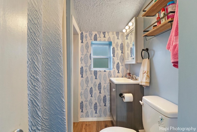 bathroom featuring wood-type flooring, toilet, a textured ceiling, vanity, and a shower with shower curtain