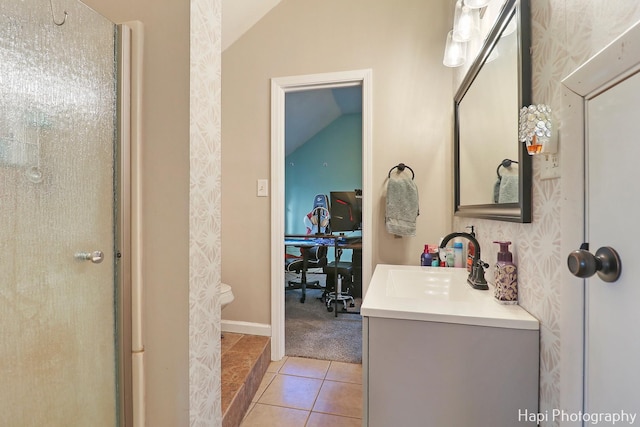 bathroom with tile patterned floors, vanity, and vaulted ceiling