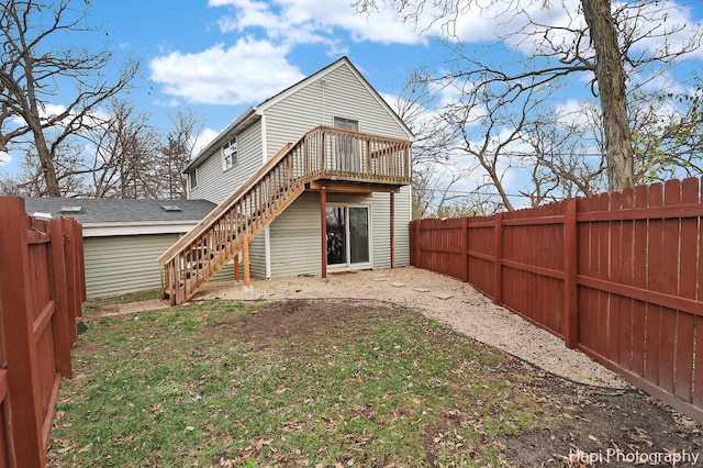 rear view of property featuring a deck and a yard