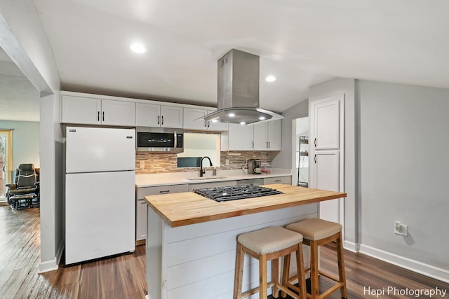 kitchen featuring island range hood, sink, white cabinetry, wood counters, and stainless steel appliances