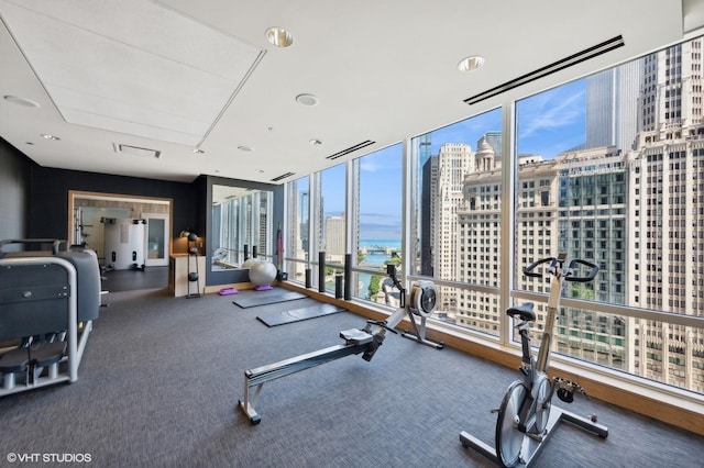 exercise room with visible vents, floor to ceiling windows, and a city view