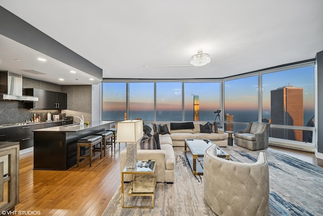 living area featuring light wood-type flooring, floor to ceiling windows, and recessed lighting