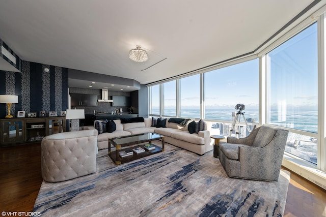 living room featuring wallpapered walls, a water view, and wood finished floors