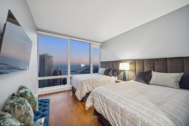 bedroom featuring hardwood / wood-style flooring and expansive windows