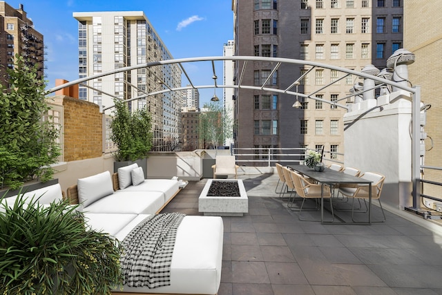 view of patio with an outdoor living space with a fire pit