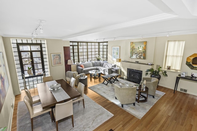 living room with hardwood / wood-style flooring, crown molding, rail lighting, and french doors