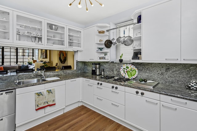 kitchen featuring sink, backsplash, stainless steel appliances, white cabinets, and dark stone counters