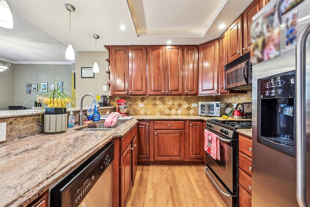 kitchen with sink, stainless steel appliances, light stone countertops, light hardwood / wood-style floors, and decorative backsplash