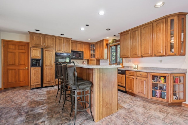 kitchen featuring a breakfast bar, dishwasher, black microwave, and a center island