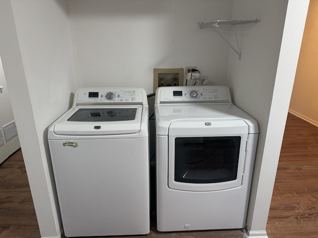 laundry area with separate washer and dryer and dark hardwood / wood-style flooring