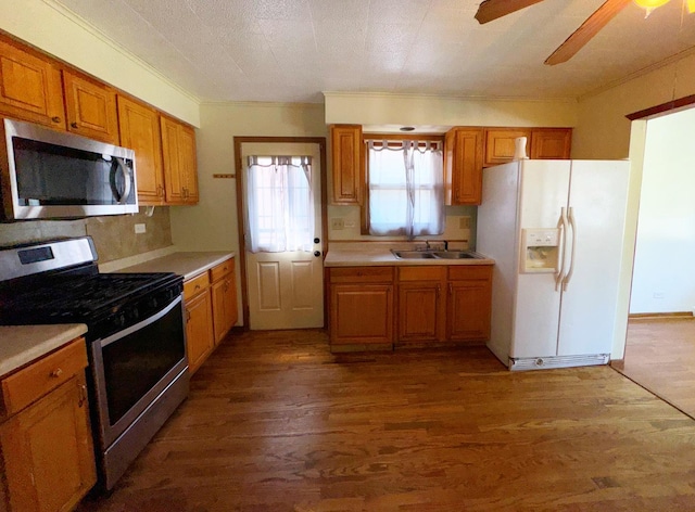 kitchen with dark hardwood / wood-style flooring, stainless steel appliances, tasteful backsplash, sink, and ceiling fan