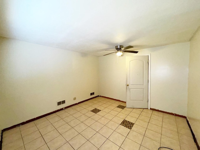 tiled spare room featuring ceiling fan