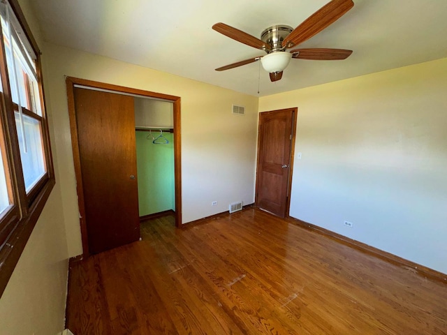 unfurnished bedroom featuring a closet, ceiling fan, and dark hardwood / wood-style flooring