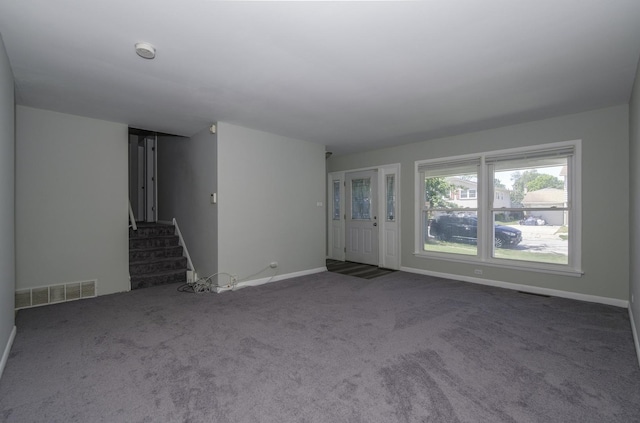 unfurnished living room with dark carpet