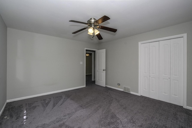 unfurnished bedroom with a closet, ceiling fan, and dark carpet