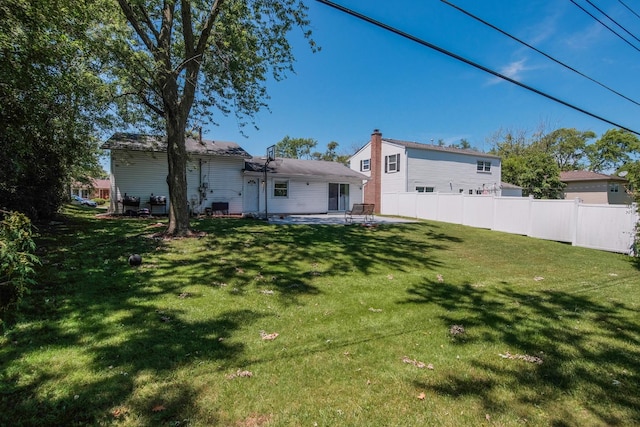 back of house featuring a patio area and a yard