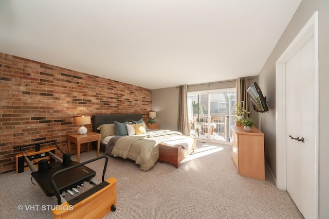 bedroom with brick wall and light colored carpet