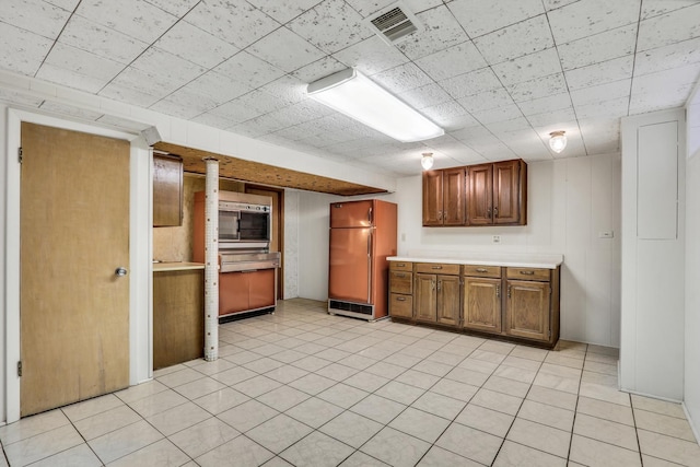 4850 N Crescent Ave, Norridge, IL 60706 - kitchen with freestanding refrigerator, brown cabinetry, light countertops, and visible vents
