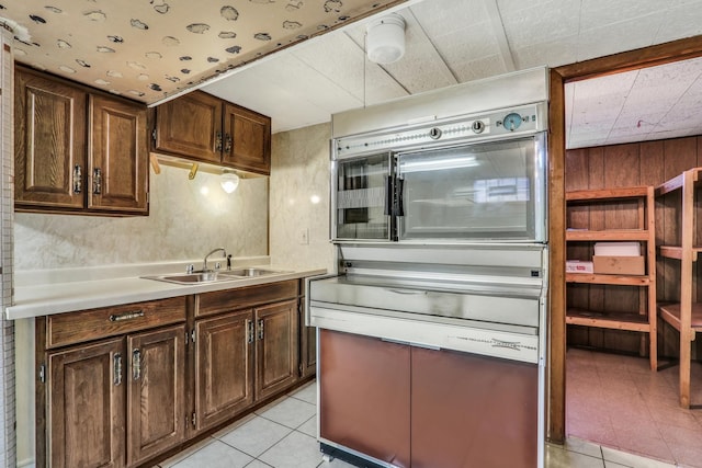 4850 N Crescent Ave, Norridge, IL 60706 - kitchen with a sink, dark brown cabinets, light countertops, and light tile patterned floors