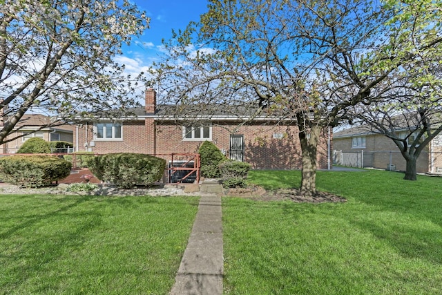 4850 N Crescent Ave, Norridge, IL 60706 - view of front facade with a chimney, a front yard, brick siding, and fence