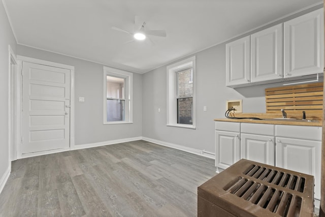 kitchen with white cabinets, light hardwood / wood-style flooring, and ceiling fan