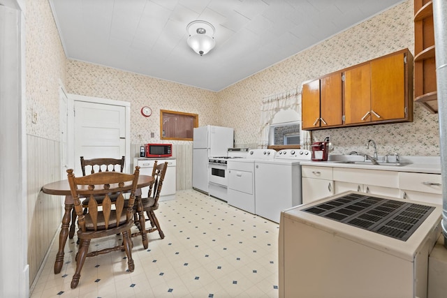 kitchen featuring sink, white appliances, and washing machine and clothes dryer