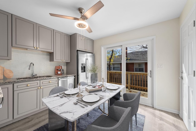 dining room featuring light hardwood / wood-style floors, sink, and ceiling fan