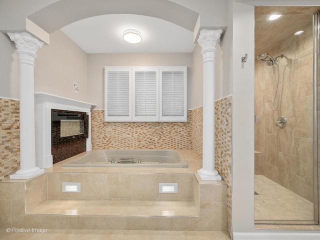 bathroom with decorative columns and separate shower and tub