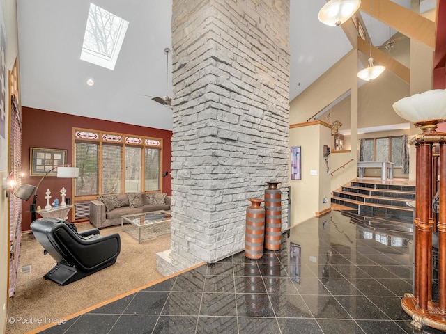 living room with a towering ceiling and a skylight