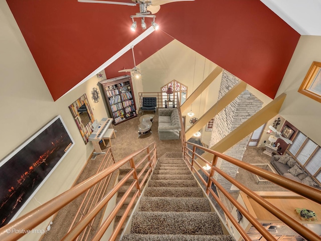 staircase featuring ceiling fan and a high ceiling