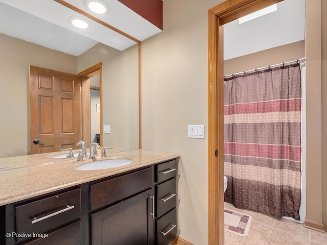 bathroom featuring a shower with curtain, vanity, tile patterned floors, and toilet