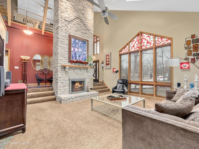 living room featuring ceiling fan, a stone fireplace, carpet flooring, and high vaulted ceiling