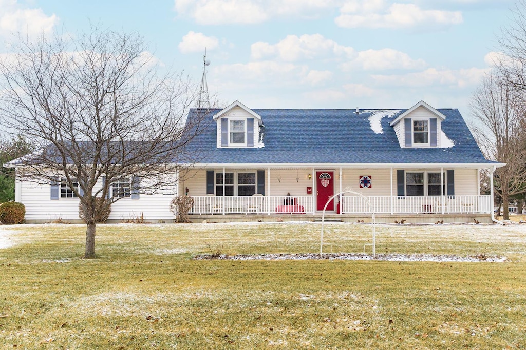 new england style home with covered porch and a front lawn