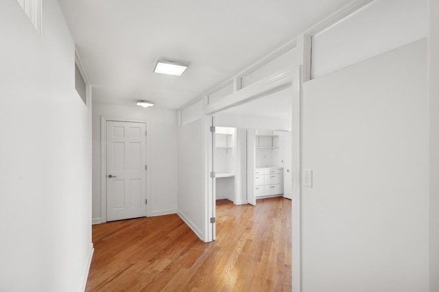 hallway with light hardwood / wood-style floors